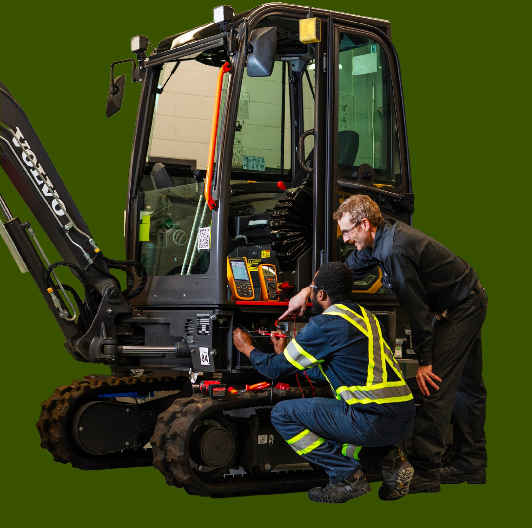 Deux personnes effectuent un diagnostic électrique sur une mini-excavatrice.